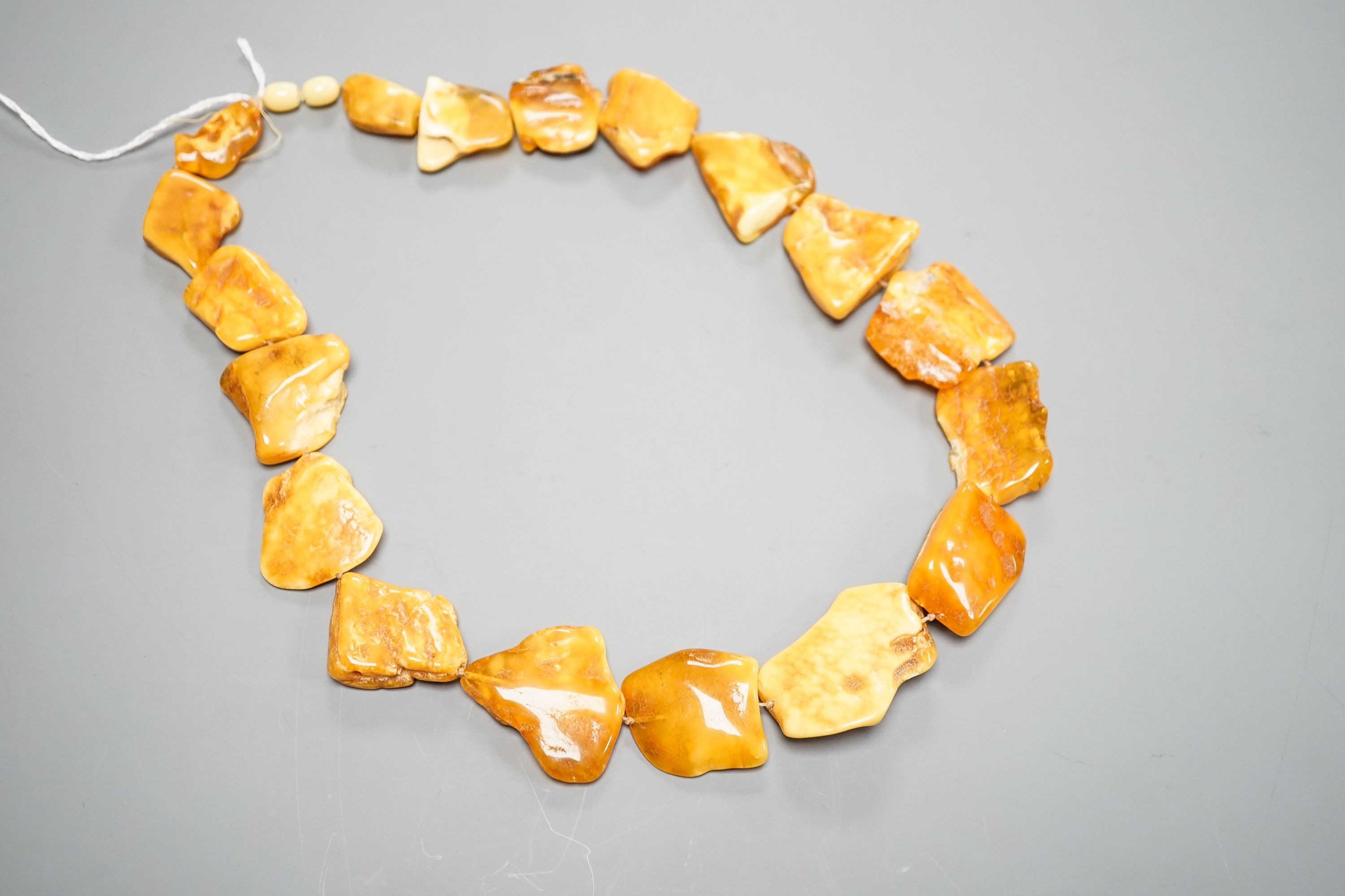 A graduated amber pebble necklace, 56cm gross weight 79 grams, (a.f.).